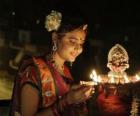 Женщины на коленях с керосиновой лампой в ее руку в празднование Дивали